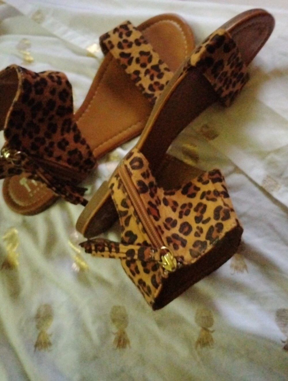 pair of Tiara brand leopard print ankle strap sandals.